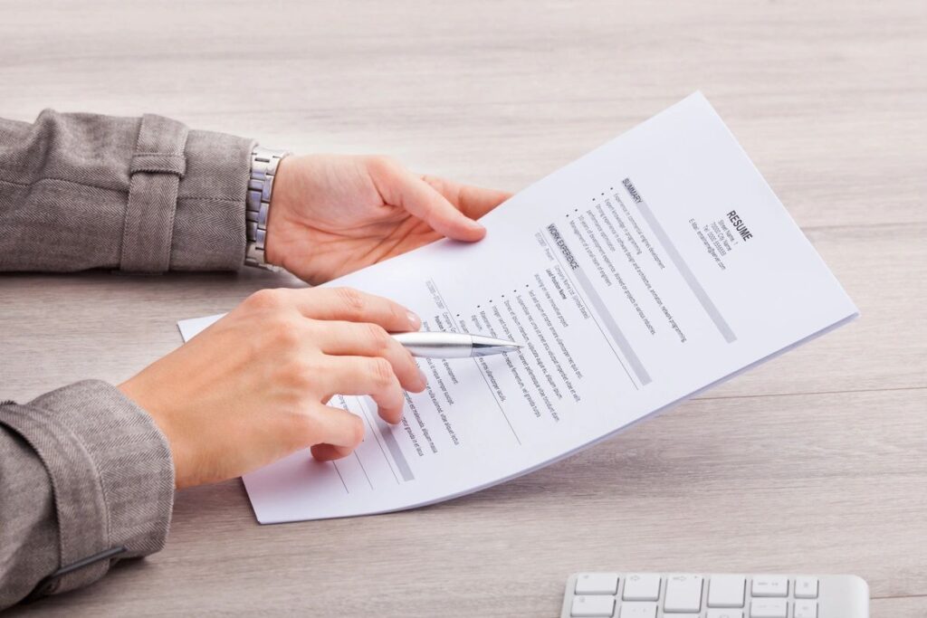 a hand pointing at a resume