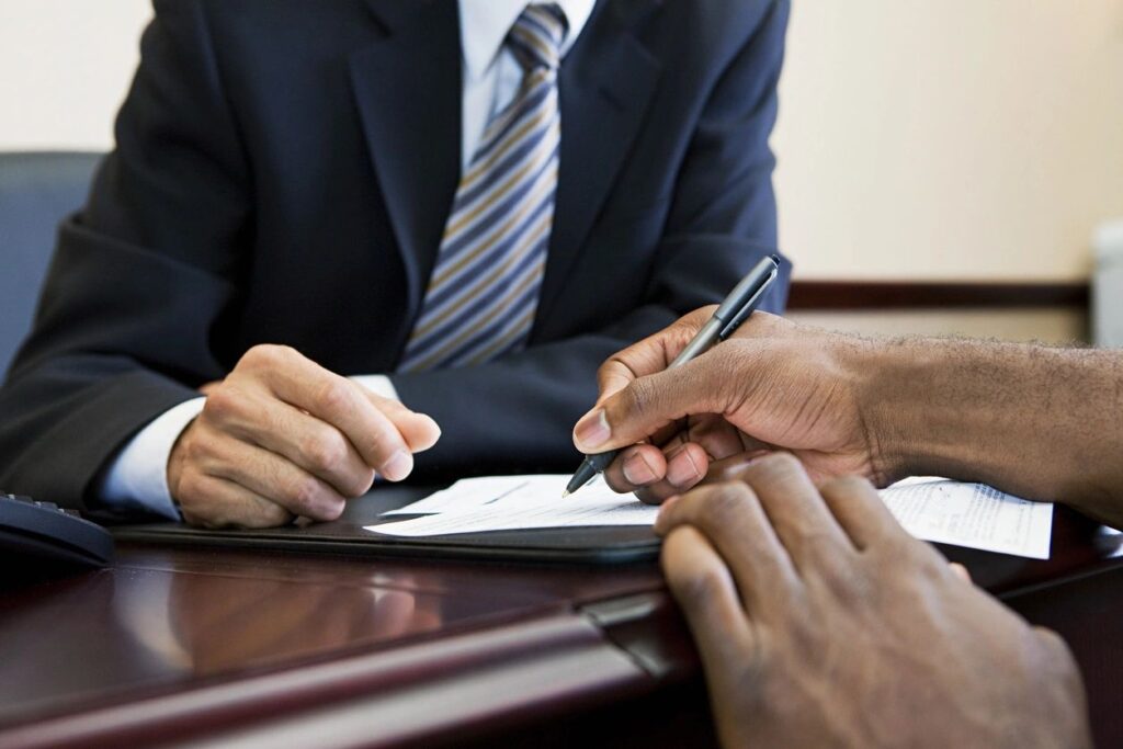 guy signing a paper in a bank