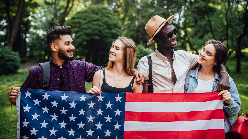 Happy four students with us flag