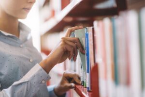 woman taking book off the bookshelf